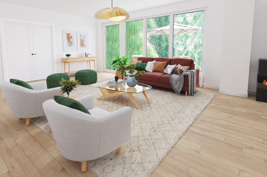 Helles Wohnzimmer mit rotem Sofa, zwei grünen Sesseln und großen Fenstern.
