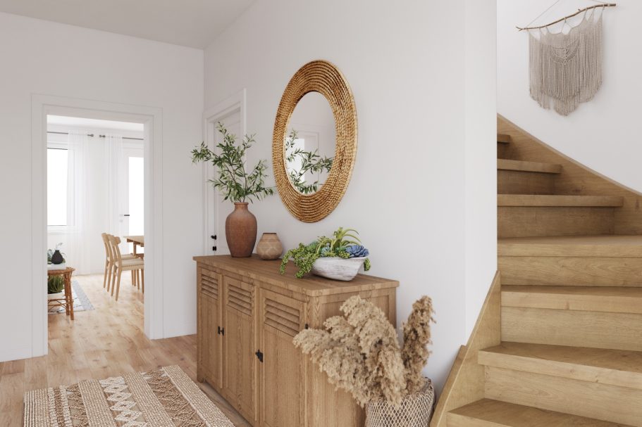 Heller Flur mit Holzkommode, runder Spiegel und Treppe zu weiteren Räumen.