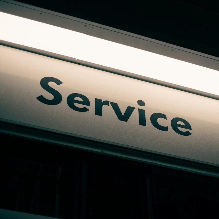 Beleuchtetes Schild mit dem Wort "Service" in großer Schrift.